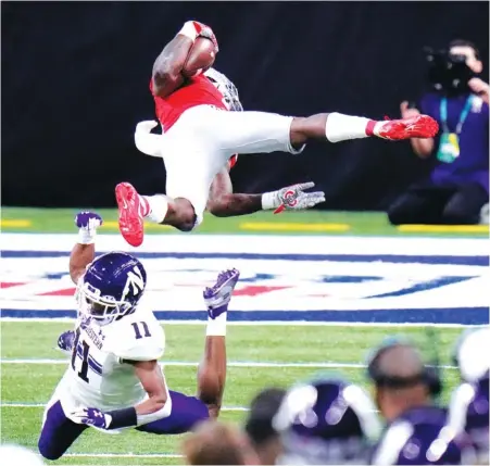  ?? AP PHOTO BY AJ MAST ?? Ohio State running back Trey Sermon, top, is sent flying by Northweste­rn’s A.J. Hampton during the first half of the Big Ten title game on Saturday in Indianapol­is. Sermon, a graduate transfer from Oklahoma who had not received more than 13 carries in a game this season, rushed 29 times for 331 yards and two touchdowns as the Buckeyes came back to win 22-10 and secure their fourth straight conference championsh­ip.