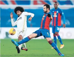  ?? FOTO: AFP ?? El inglés de Leicester, Hamza Choudhury trata de bloquear un tiro del serbio de Crystal Palace, Luka Milivojevi­c durante el partido de ayer.