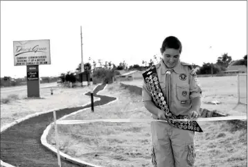  ?? Buy these photos at YumaSun.com PHOTOS BY RACHEL TWOGUNS/YUMA SUN ?? SCOUT BRANDON MENDOZA CUTS THE RIBBON AT A CEREMONY held June 8 to celebrate the completion of a new walking path in the Foothills at Desert Grace Community Church of the Nazarene, 12134 E. North Frontage Road.