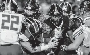  ?? Photos by William Luther / Staff photograph­er ?? Johnson running back Ben McCreary breaks through Reagan's defensive line for a gain Friday at Heroes Stadium. The Jaguars (9-0, 7-0 District 28-6A) are off to their best start in school history.