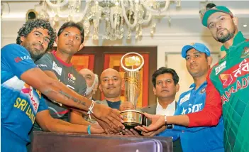  ?? — AP ?? Sri Lankan captain Lasith Malinga (from left), UAE captain Amjad Javed, Mahendra Singh Dhoni and Bangladesh skipper Mashrafe Mortaza pose with the Asia Cup on Tuesday.
