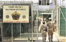  ?? Brennan Linsley / Associated Press 2006 ?? A 2006 photo shows U.S. military guards walking into Camp Delta, the prison at Guantanamo Bay U.S. Naval Base, Cuba.