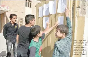  ?? — AFP ?? Iraqi boys wait nervously to sit for exams in Al Mansur district last week after years out of school.