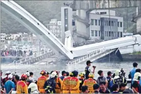  ?? SAM YEH/AFP ?? Taiwanese rescue personnel look on at a bridge after it collapsed in the Nanfangao fish harbour in Suao township on Monday.