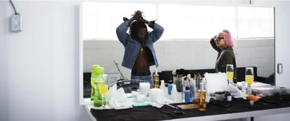  ??  ?? April 11: Cartier ties his dreads in between looks during a photo shoot for BRICK Magazine, a publicatio­n about the new age of hip-hop culture. Makeup artist Mila Victoria looks on.