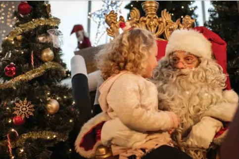  ?? FOTO: JOACHIM LADEFOGED ?? Lilly Friis på tre år fortaeller julemanden i Storcenter Nord, Mogens Koelmeyer, at hun til jul ønsker sig en enhjørning, der kan synge.