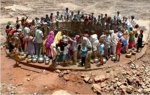  ?? AFP ?? Indian villagers gather around a well to fill their pots with water during a drought in Natwargadh village, near Ahmedabad, the capital of the Indian state of Gujarat. —