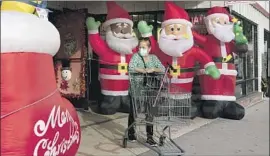  ?? Jae C. Hong Associated Press ?? CALIFORNIA’S surge in overall virus cases, as well as cases of the Omicron variant, is likely tied to holiday gatherings. Above, a shopper in Inglewood on Monday.