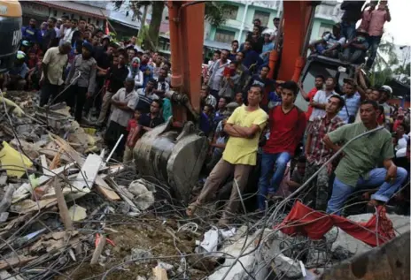  ?? GETTY IMAGES ?? Relatives and neighbours watch anxiously as Indonesian army and rescue workers look for survivors in the rubble in Lueng Putu town, Aceh Province.