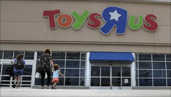  ?? ERIC GAY — THE ASSOCIATED PRESS FILE ?? In this file photo, shoppers walk into a Toys R Us store, in San Antonio. Toys R Us says it will be closing some U.S. stores and converting others to cobranded locations as it continues to deal with its financial restructur­ing following its bankruptcy...