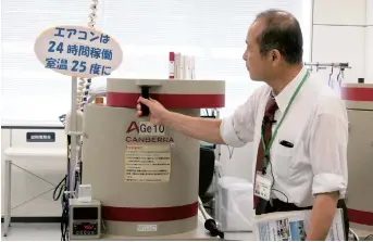  ??  ?? Kenji Kusano, director of the Fukushima Agricultur­al Technology Center, makes radiation tests on fish samples at the center in Koriyama.