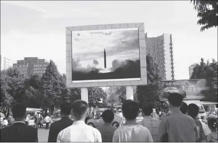  ?? AP PHOTO ?? People watch a launching of a Hwasong-12 strategic ballistic rocket aired on a public TV screen at the Pyongyang Train Station in Pyongyang, North Korea on Saturday.