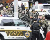  ?? Alexandra Wimley The Associated Press ?? Law enforcemen­t officers secure the scene where multiple people were shot Saturday at a synagogue in Pittsburgh.