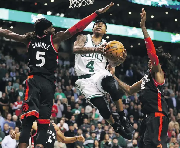  ?? — GETTY IMAGES ?? Boston Celtics guard Isaiah Thomas squeezes his way past Toronto Raptors DeMarre Carroll, left, and Lucas Nogueira during the fourth quarter of their game Wednesday at TD Garden in Boston. The Celtics won 109-104 thanks to Thomas’ 44 points.