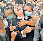 ??  ?? The mother (centre) of slain protester Khant Nyar Hein reacts at his funeral in Yangon on Tuesday.