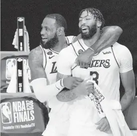  ?? MARK J. TERRILL/AP ?? LeBron James and Anthony Davis celebrate after the Lakers’ title-clinching win on Oct. 11.