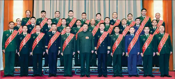  ?? LI GANG / XINHUA ?? President Xi Jinping, also chairman of the Central Military Commission, takes a group photo with representa­tives from model units and model personnel before a Central Military Commission meeting in Beijing on Friday.