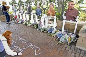  ?? Brian Cassella/Chicago Tribune/TNS ?? Residents deliver flowers and leave chalk messages at a memorial depicting the seven people killed after a mass shooting at the Fourth of July parade in Highland Park.