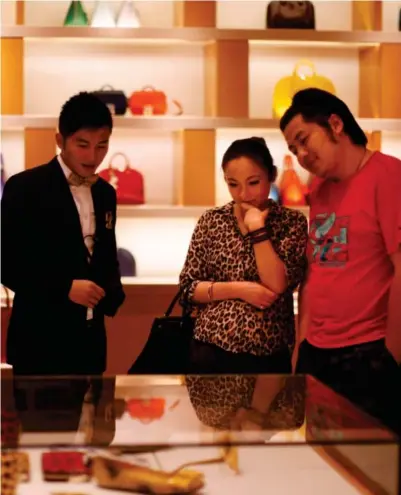  ?? Foto: Carlos Barria, Reuters/ntb ?? ⮉ Luksus: Et par handler i en Louis Vuitton-butikk i Shanghai.