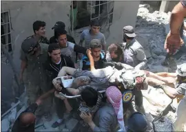  ?? SYRIAN CIVIL DEFENSE WHITE HELMETS VIA AP ?? Syrian White Helmet civil defense workers and civilians carry an injured man on a stretcher Saturday after an airstrike hit the northern town of Ariha in Syria.