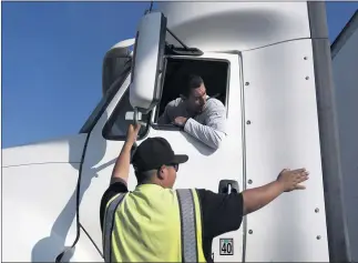  ?? JAE C. HONG — THE ASSOCIATED PRESS ?? Senior instructor Markus Juarez, bottom, talks to student driver Jaime Rojas at California Truck Driving Academy in Inglewood. Amid a shortage of commercial truck drivers across the U.S., a Southern California truck driving school is seeing an unpreceden­ted increase in enrollment numbers.