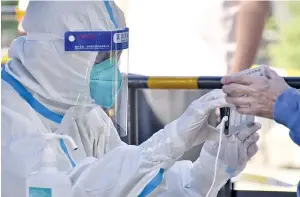  ?? Photo: Xinhua ?? A staff member helps a citizen to register informatio­n before nucleic acid testing in Chaoyang District of Beijing, China on May 13, 2022.