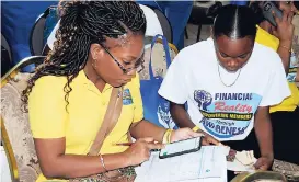  ??  ?? Credit union volunteer, JodiAnn Deslandes (left), assisting a student with her budget.