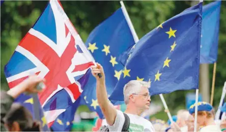  ?? — AFP ?? PRO-EU demonstrat­ors hold placards and wave European Union flags during an anti-brexit protest outside the Houses of Parliament in London.