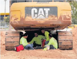  ??  ?? Constructi­on workers in Phoenix took shelter from the sun where they could find it, while pets also got a bit of protection from the heat.