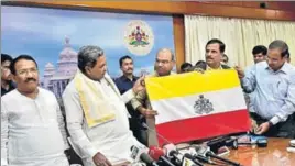  ??  ?? ■ Karnataka chief minister Siddaramai­ah (second from left) unveils the proposed state flag. While it retains the classic bands of yellow on top and red at the bottom, a strip of white, symbolisin­g peace, has been added. At the heart of the flag is the official emblem of the state, the coat of arms of the erstwhile state of Mysore. HT PHOTO