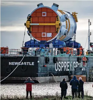  ?? Picture: Ben Birchall/PA ?? People watch the nuclear reactor for Hinkley Point C – the first for a British power station in over 30 years – arrive by barge at Combwich Wharf on Somerset’s River Parrett, in February 2