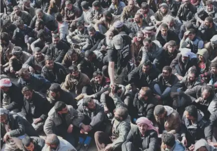  ??  ?? An Iraqi soldier distribute­s cigarettes, which were banned by Islamic State militants, to displaced men who fled their homes because of fighting between Iraqi security forces and militants west of Mosul, Iraq, on Sunday. Khalid Mohammed, The Associated...