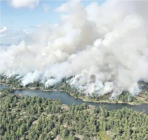  ?? DAN LEONARD / RESPONSE SPECIALIST / AFFES IGNITION / THE CANADIAN PRESS ?? An aerial view shows the extent of Parry Sound 33 fire being fought in Ontario by firefighte­rs from across Canada, the United States and Mexico. The wildfire could force the closure of a stretch of the Trans-Canada Highway.