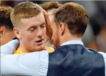  ??  ?? Beaten but unbowed: Manager Gareth Southgate consoles keeper Jordan Pickford