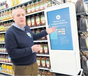  ??  ?? Mike Hanrahan, CEO of Walmart’s Intelligen­t Retail Lab, discusses a kiosk that describes to customers the high technology in use at a Walmart Neighborho­od Market, Wednesday, April 24, 2019, in Levittown, New York.