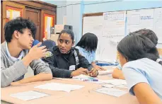  ??  ?? Una oficial de policía con jóvenes de la comunidad./CORTESIA.