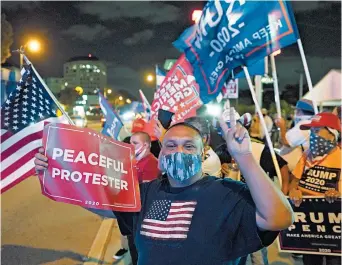  ?? WILFREDO LEE/AP ?? Supporters of President Donald Trump chant and wave flags during Election Night in Miami’s Little Havana.