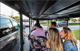  ?? RICHARD GRAULICH / THE PALM BEACH POST ?? Local co-workers (from left) Vinny Sanchez (left), Breanna Brady, Dan Fillhaber and Kayleigh Nolan enjoy a ride with Zeke’s Golf Cart Taxi service Thursday. “Why drive when you can have a free ride?” Nolan said.