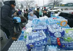  ?? (Jim Young/Reuters) ?? VOLUNTEERS DISTRIBUTE bottled water in Flint, Michigan, in 2016.