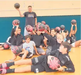  ?? Photo / Supplied ?? Lake Taupo¯ Basketball Associatio­n community participat­ion manager Tony Strange with Mountview School students showing off their free basketball­s.