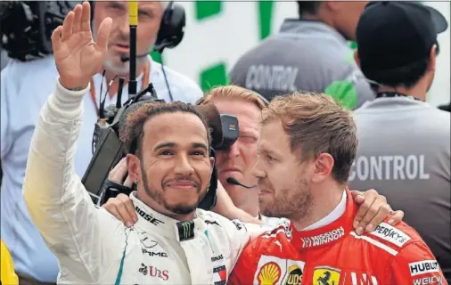  ??  ?? CAMPEONES. Sebastian Vettel felicitó a Lewis Hamilton por su quinto título Mundial nada más terminar la carrera de México.