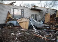  ?? (AP/The Des Moines Register/Bryon Houlgrave) ?? Debris covers a vehicle beside a damaged home in Rudd, Iowa, on Thursday after a band of severe weather with a tornado hit the small north central Iowa town late Wednesday.