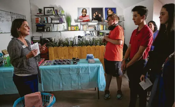  ?? Photos by Godofredo A. Vásquez / Staff photograph­er ?? Cultivatin­g Families founder Rev. Amy Bezecny, left, instructs students from The Williams School on how to put together “first-night” kits, which are used by children who are picked up from unsafe situations to be fostered overnight, during a gathering at First United Methodist Church.