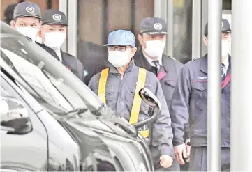  ??  ?? A person believed to be Ghosn (wearing blue cap) leaves the Tokyo Detention House in Tokyo, Japan. — Reuters photo