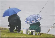  ?? BEA AHBECK/NEWS-SENTINEL ?? People use umbrellas to stay dry while fishing at Lodi Lake on March 16. Another 1 to 3 inches of rain are expected in the Lodi area this week.