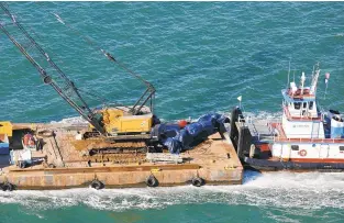  ?? KRISTEN ZEIS/STAFF ?? Remnants of the truck cab, covered in a tarp, were transporte­d after being recovered from the waters.