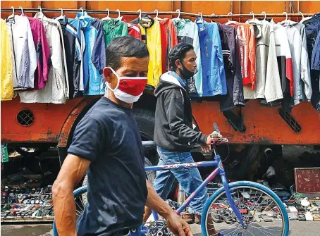  ?? Reuters ?? People wearing protective face masks are seen at the Jatinegara market area on Sunday amid the coronaviru­s disease (COVID-19) outbreak in Jakarta.