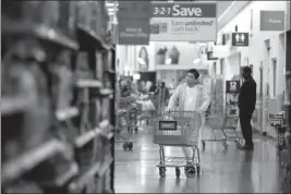  ?? ASSOCIATED PRESS ?? IN THIS 2017 FILE PHOTO, a man pushes a cart while shopping at a Walmart store in North Bergen, N.J. Walmart Inc. reported strong earnings Thursday.