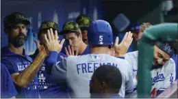  ?? CHRIS SZAGOLA – THE ASSOCIATED PRESS ?? The Dodgers’ Freddie Freeman, center, returns to the dugout after scoring in the first inning.
