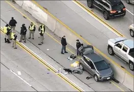  ?? KTLA ?? A CAR pocked with bullet holes sits next to the median on the 405 Freeway near Burbank Boulevard after a shooting that left one person hospitaliz­ed.